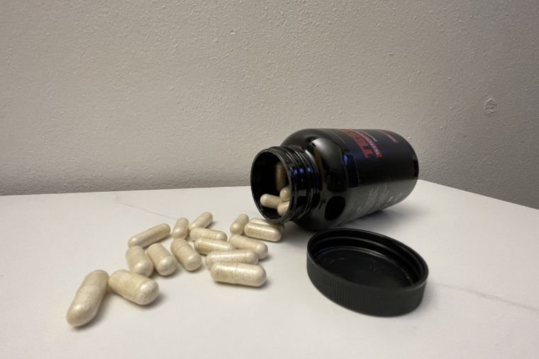 A bottle of Testosil on its side with capsules spilling out of it