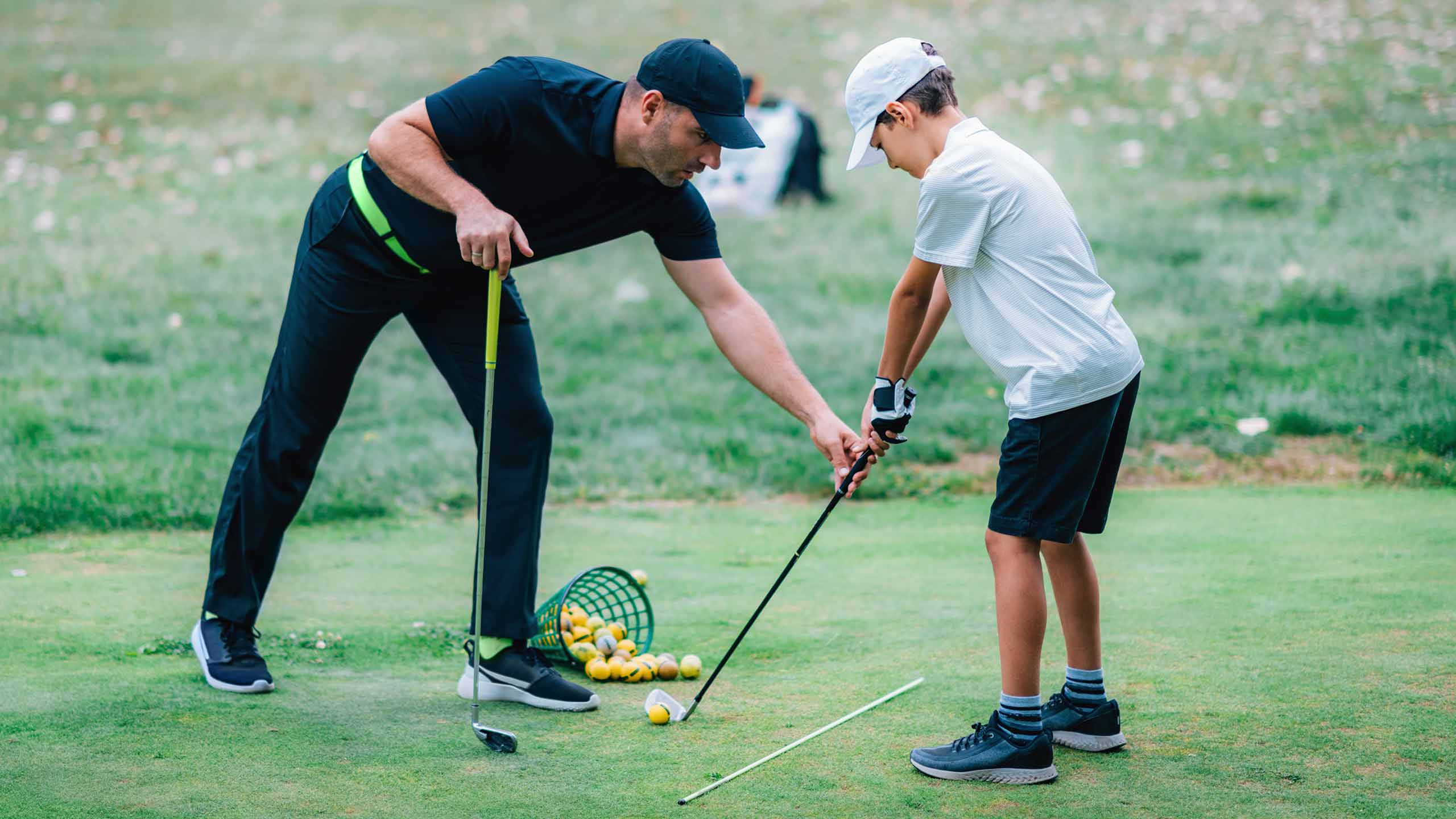 A pro gives a golf lesson.