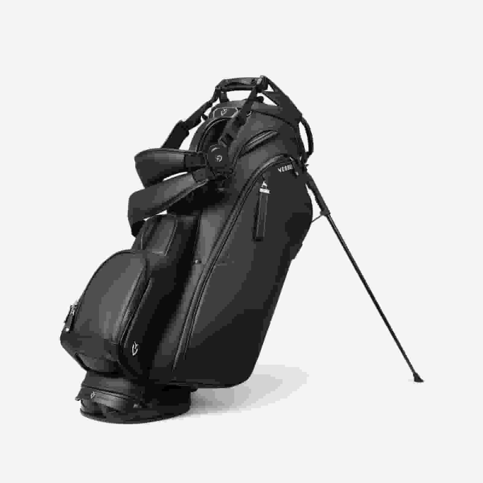 A black golf bag with multiple zippered pockets, a handle, shoulder straps, and a stand extended, positioned upright against a plain white background&mdash;an excellent choice for those seeking the best golf bags 2026.