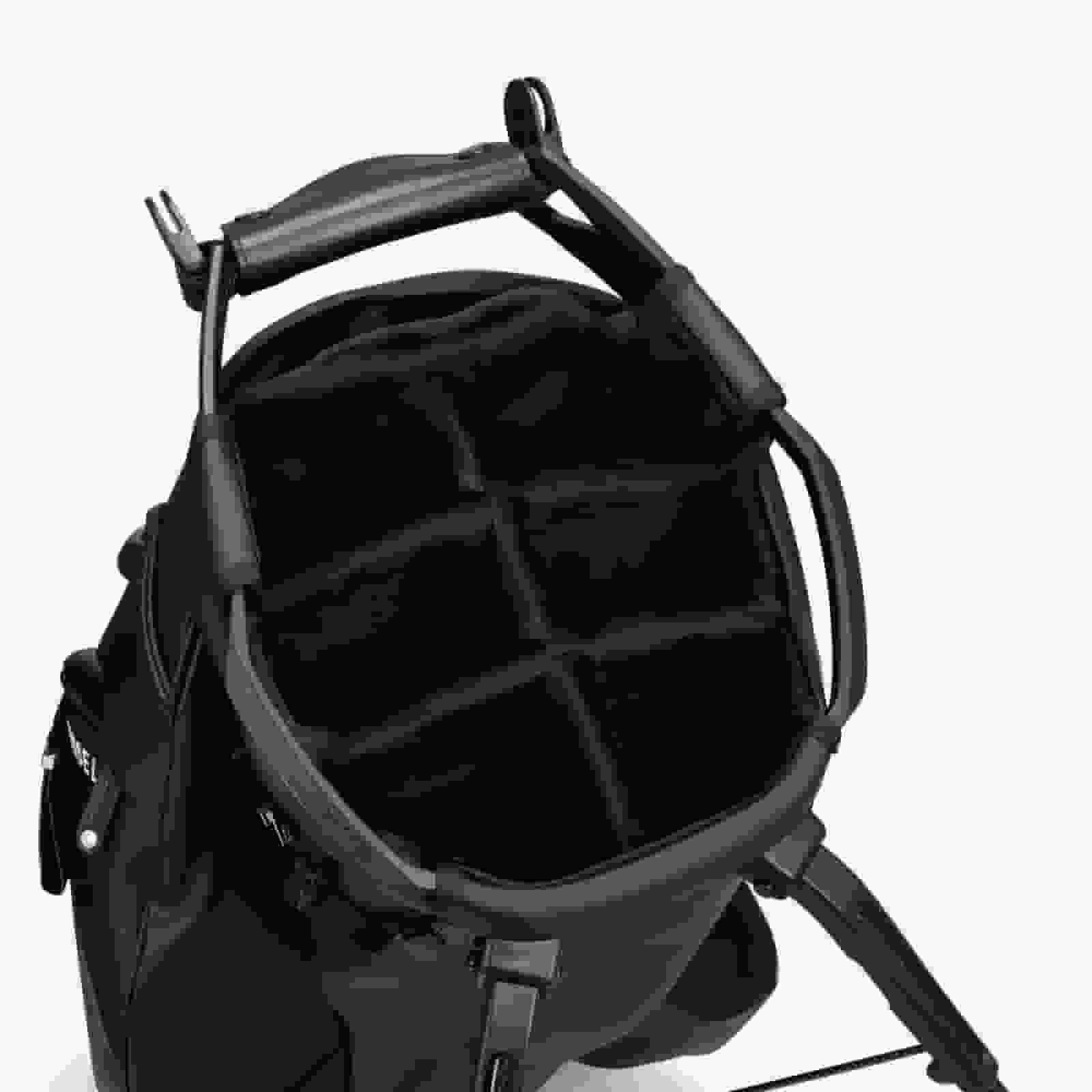 A black camera backpack with the main compartment open, revealing padded, adjustable dividers for organizing camera gear&mdash;offering versatility and smart design inspired by the best golf bags 2026. Features comfortable shoulder straps and a sturdy top handle.
