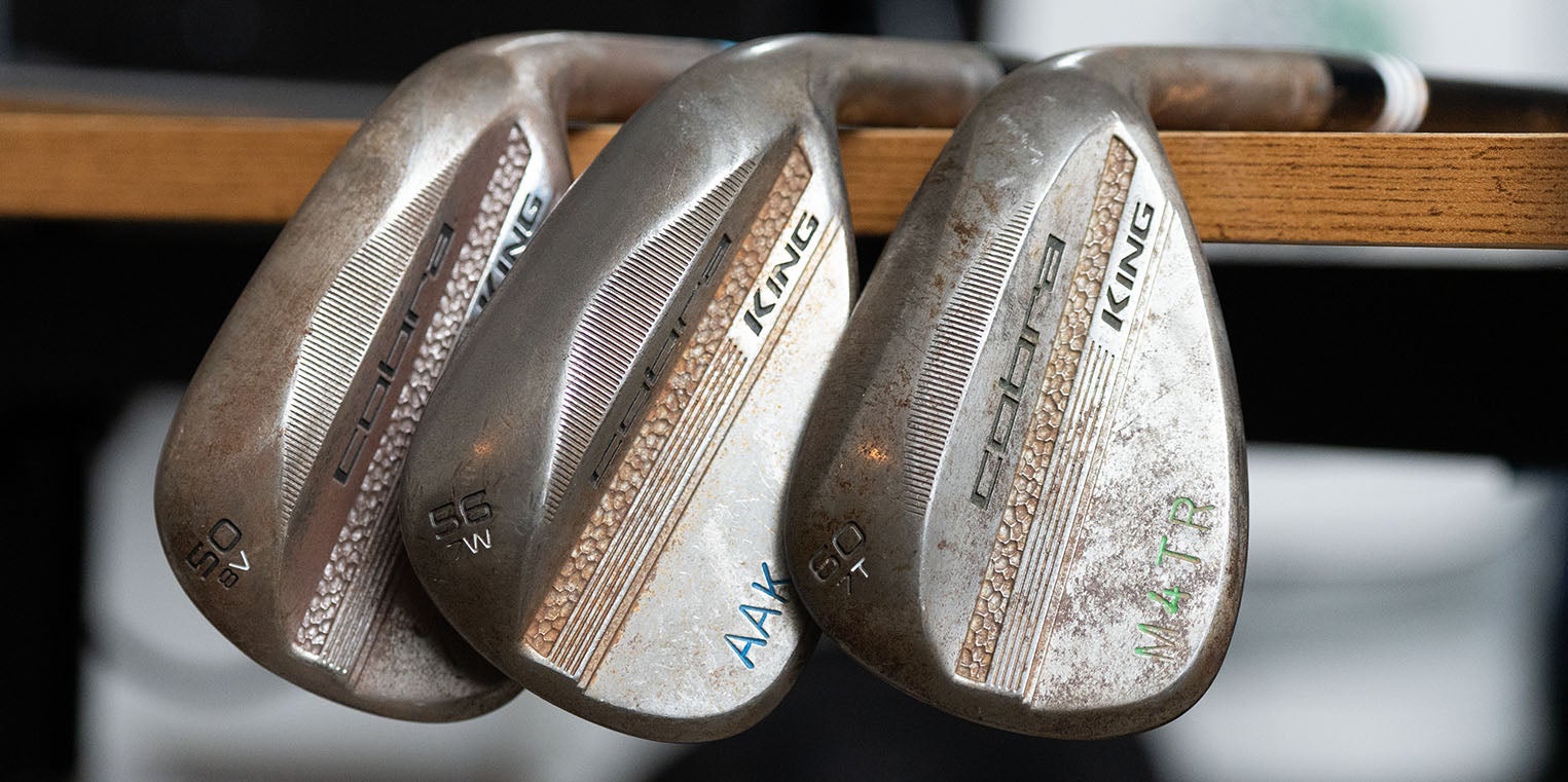 Three worn Cobra King golf wedges with visible loft numbers (52, 56, 60) and engraved initials rest against a wooden surface, showing signs of frequent use and some rust&mdash;classic evidence that these once made the perfect wedges for any golfer. Ready to be Fully Fit 2026.