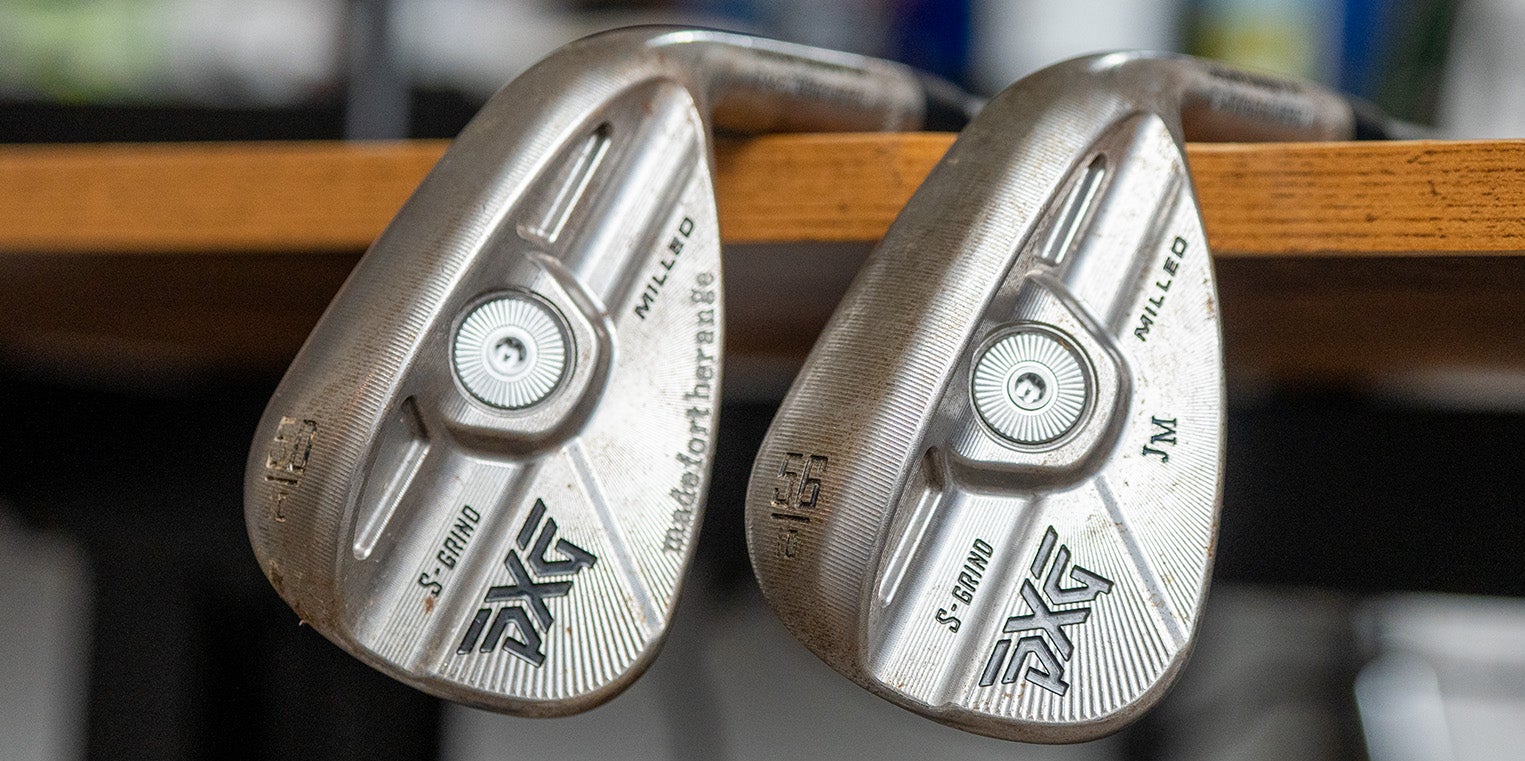 Two metal golf club heads rest side by side on a wooden surface. Both, designed as perfect wedges, are marked with PXG, S. GRIND, Milled, and other engravings, showing signs of wear from use. These clubs are Fully Fit 2026 models, built for both performance and durability.