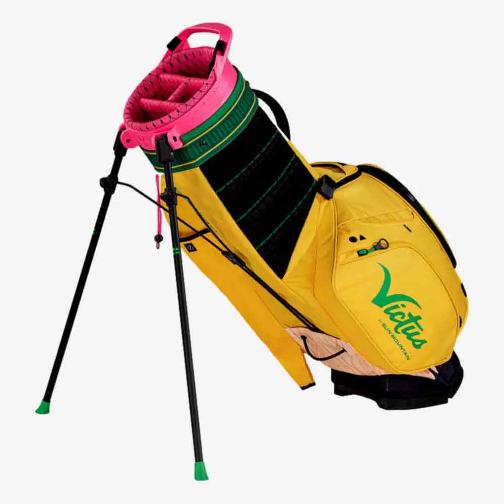 A yellow pencil golf bag with a green and pink top, green accents, and the word Virtue printed on the side. This Sun Mountain golf bag features a stand with two black legs and multiple storage pockets.