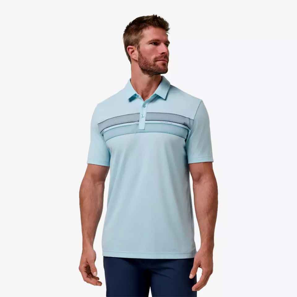 A man wearing a light blue short-sleeve polo shirt with horizontal striped accents across the chest and dark blue pants stands against a plain white background&mdash;perfect for golf gifts or stylish Father&rsquo;s Day gifts.