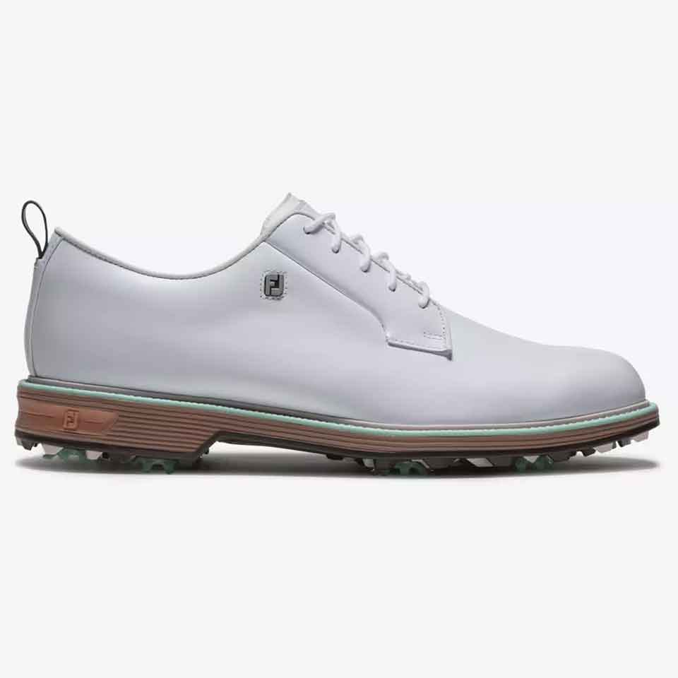 This golf shoe features white leather with laces, a brown and green rubber sole with soft spikes, and a small logo near the heel. Displayed from a side view on a plain white background, it's the ideal shoe for style and comfort on the course.