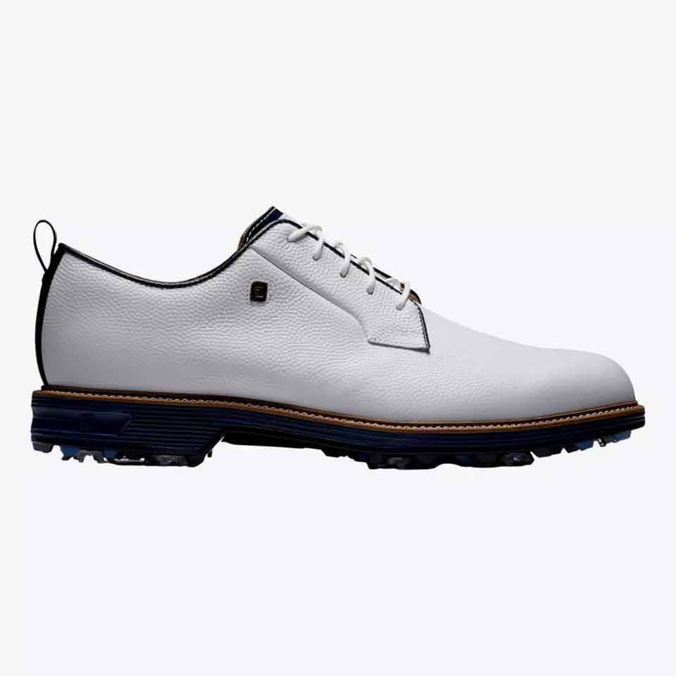 A stylish white leather golf shoe with a black sole, blue and tan detailing, black laces, and a small metal emblem on the side. This sleek shoe is shown in profile against a plain background.