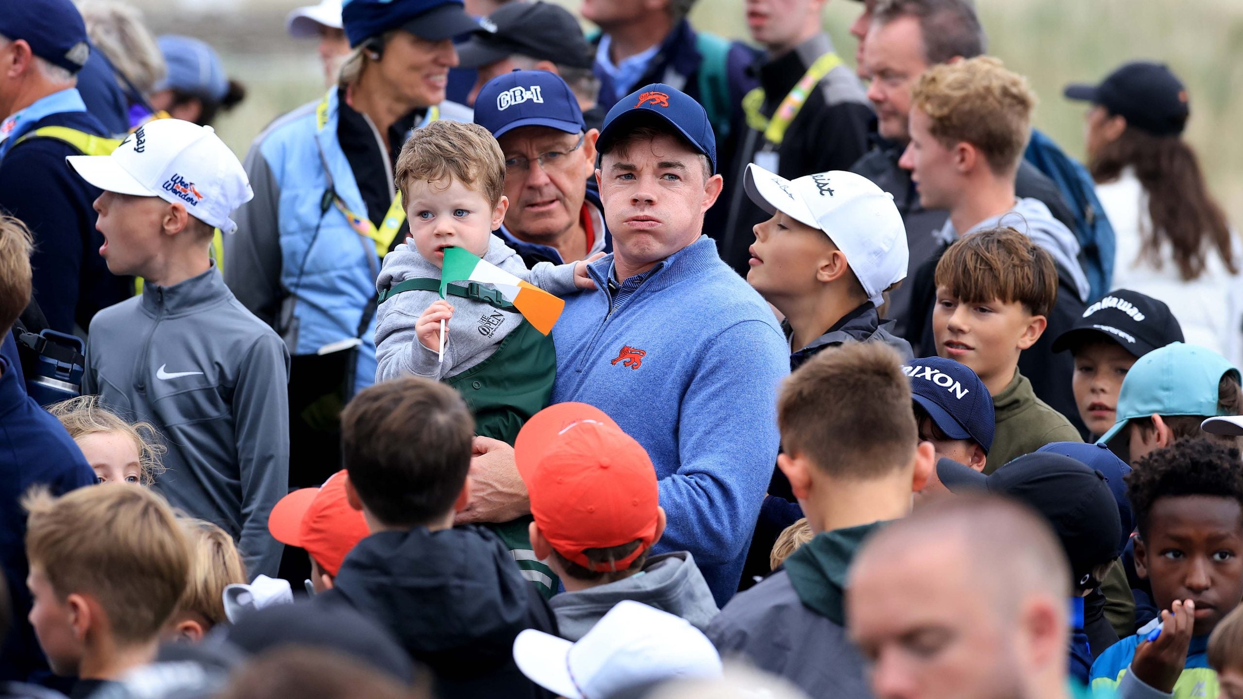 Stuart Grehan of The Great Britain and Ireland team celebrates with his young son after winning his match on the 17th green against Preston Stout of The United States team